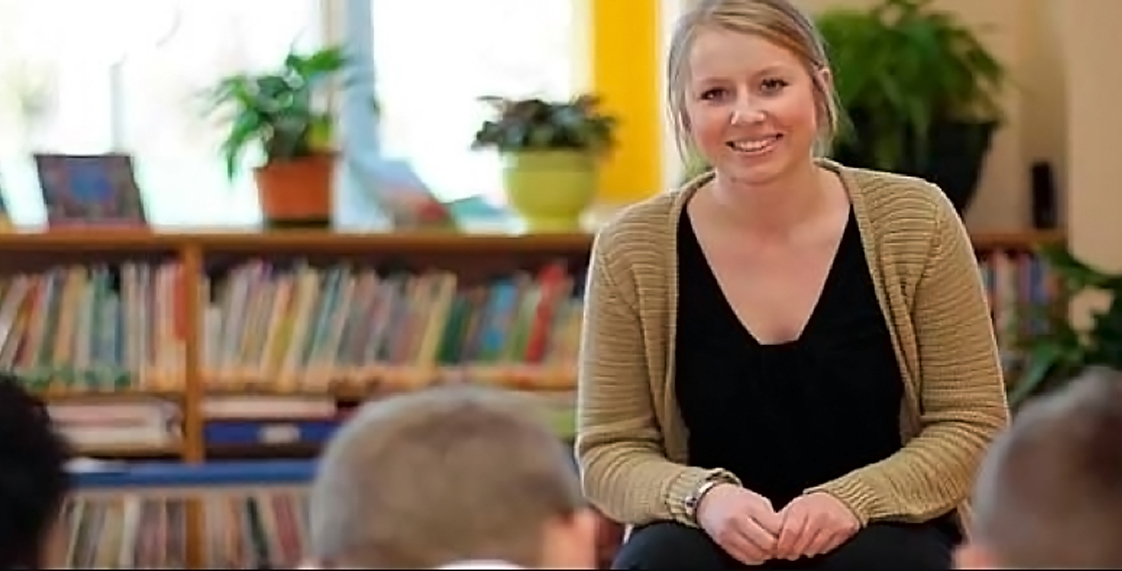 White female teacher pupils heads books